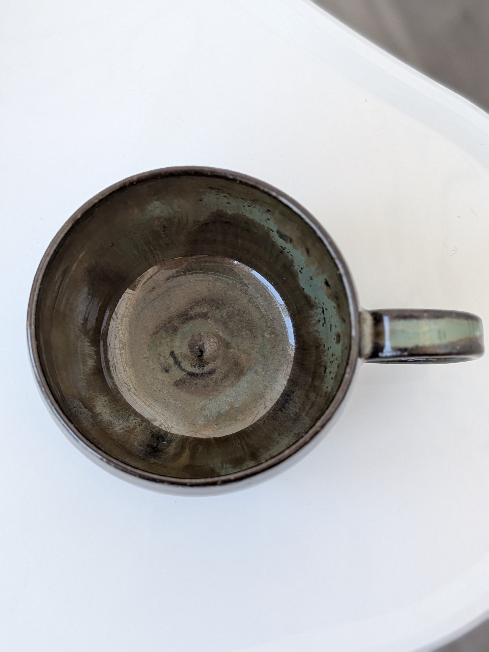 Handmade brown and green glazed ceramic cup, top view