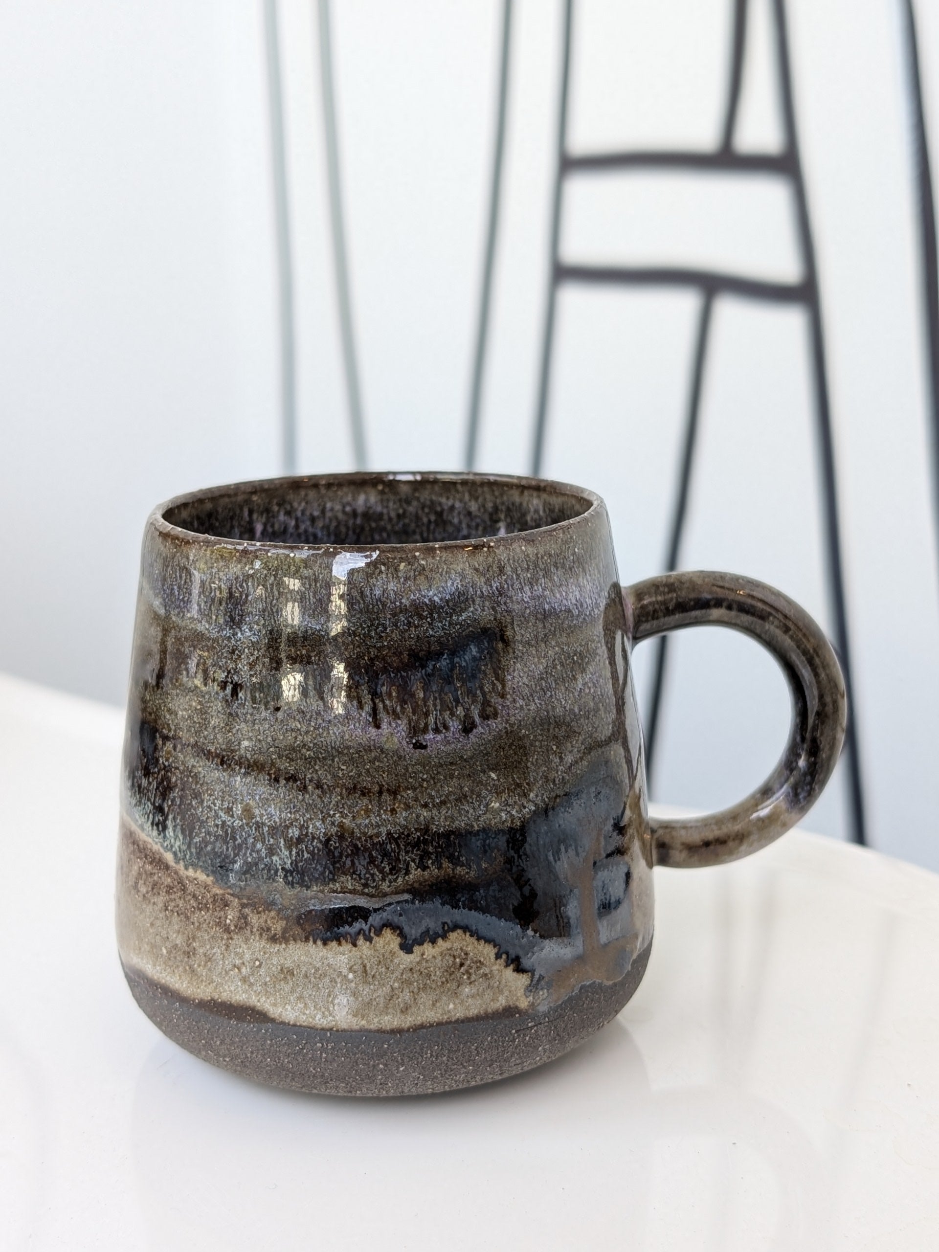 Handmade ceramic mug with a textured surface on a white background