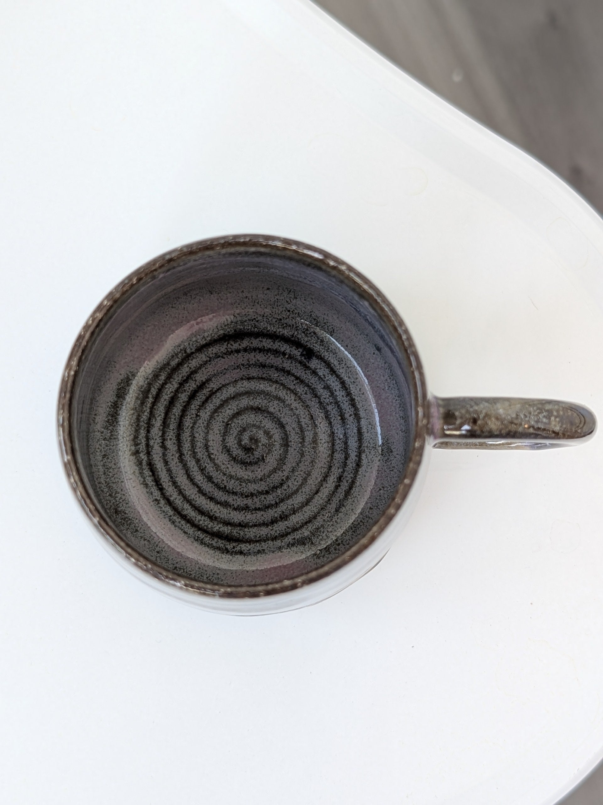 Ceramic mug with a spiral design on a white surface