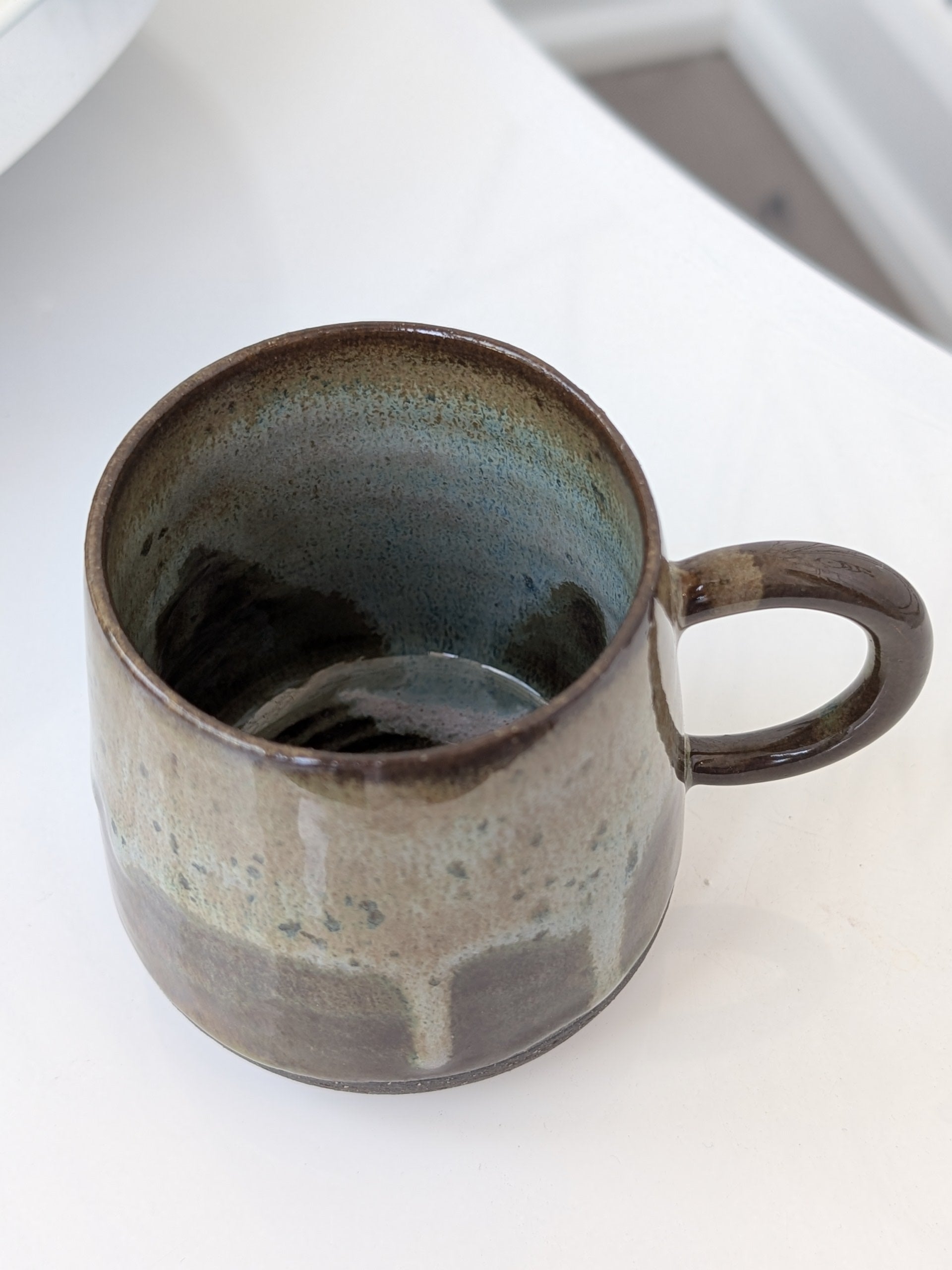 Handmade ceramic mug with a textured surface on a white background