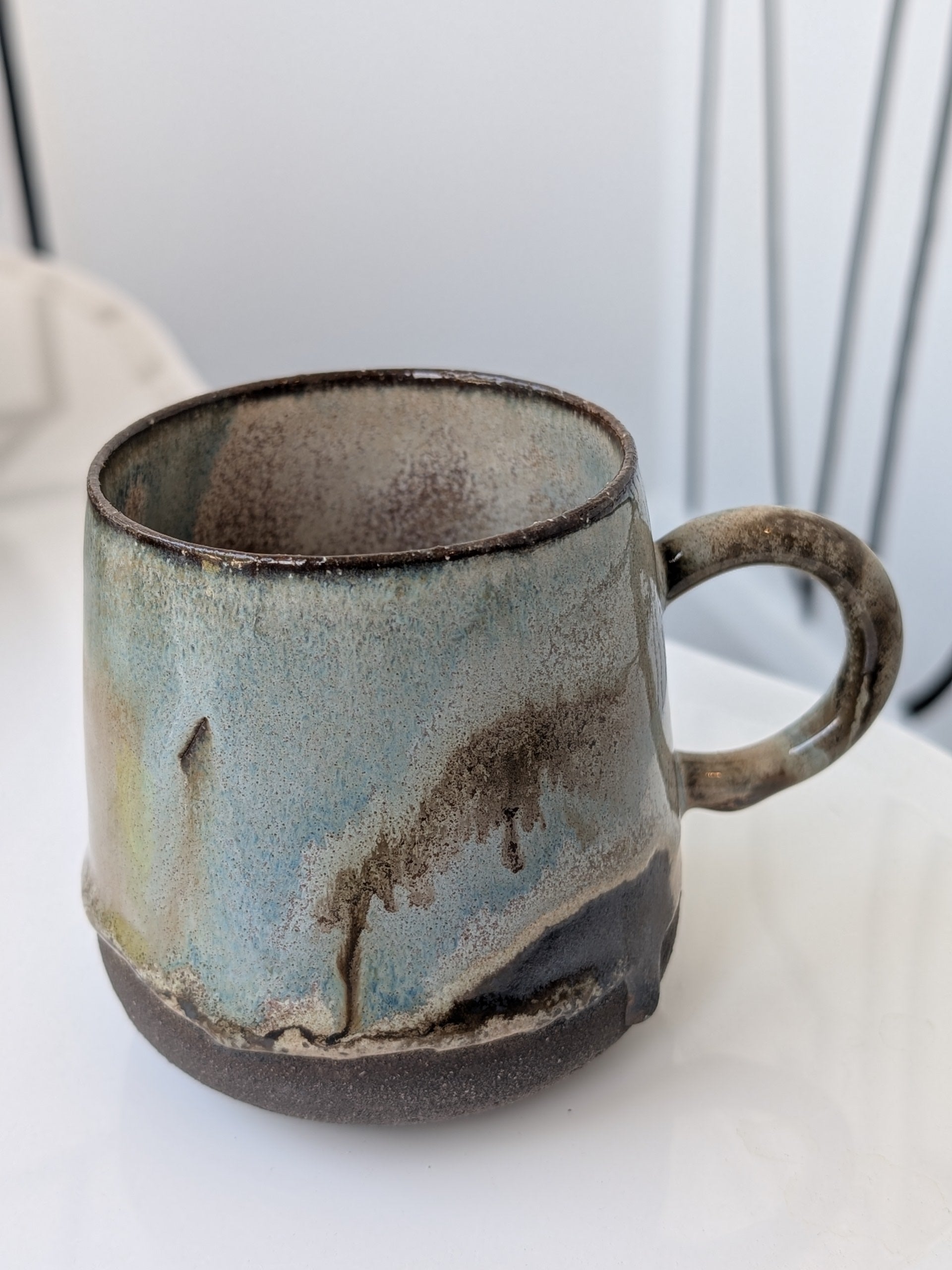 Handmade ceramic mug with a textured surface on a white background