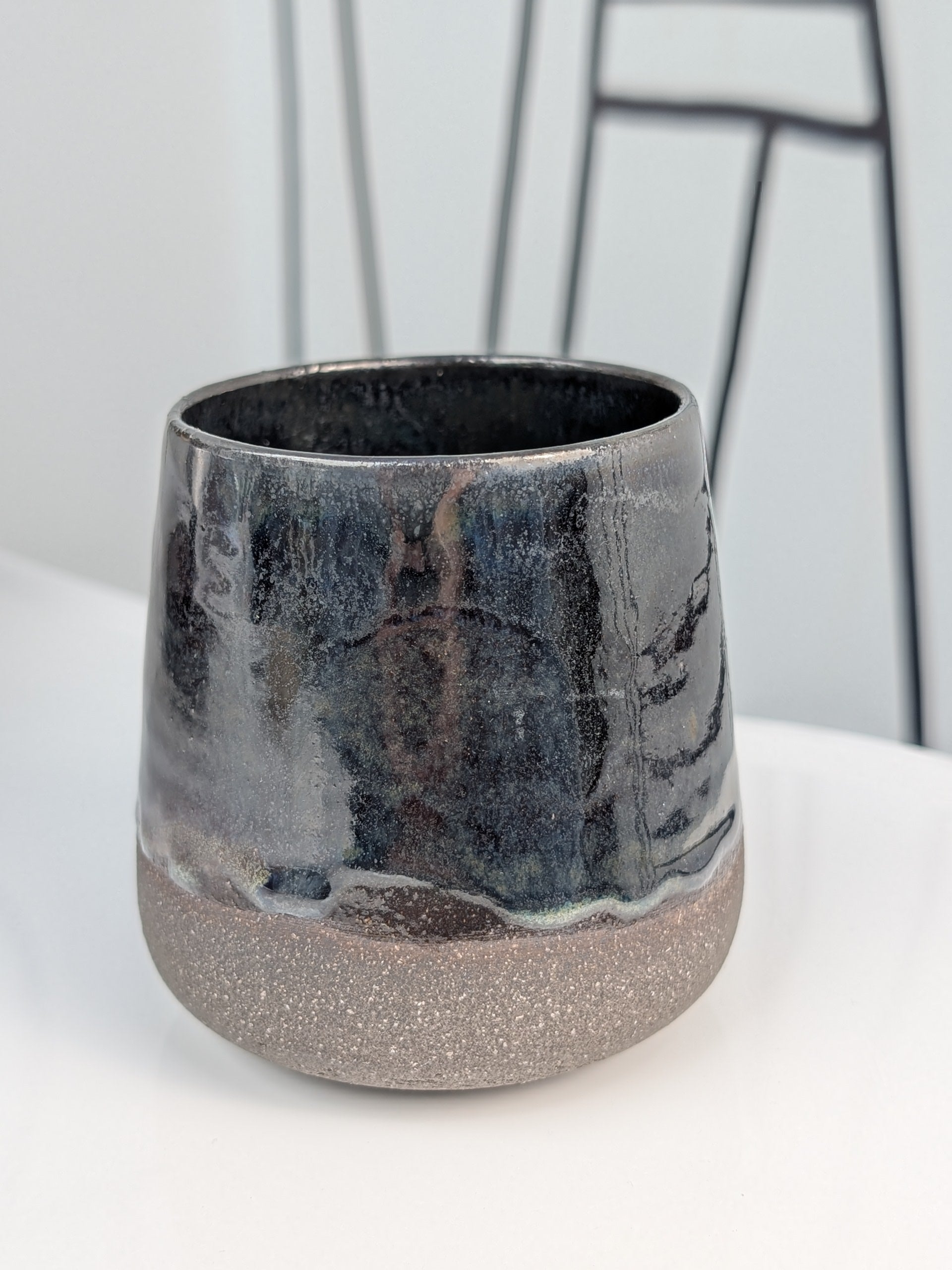 Handmade black glazed ceramic cup, front view