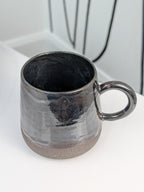 Handmade black glazed ceramic cup, isometric view