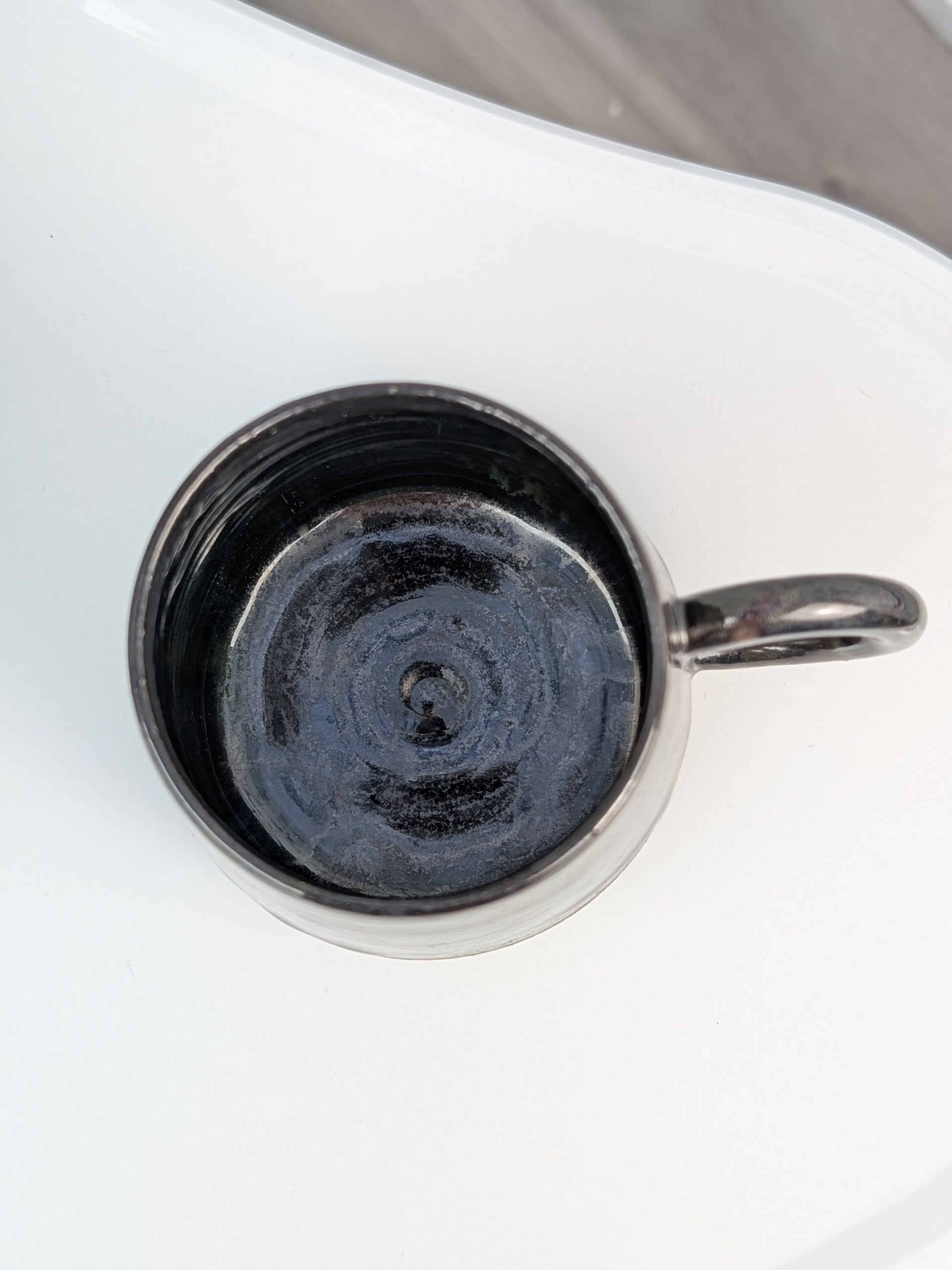 Handmade black glazed ceramic cup, top view