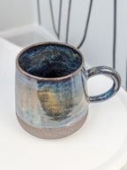 Handmade blue and brown glazed ceramic cup, isometric view