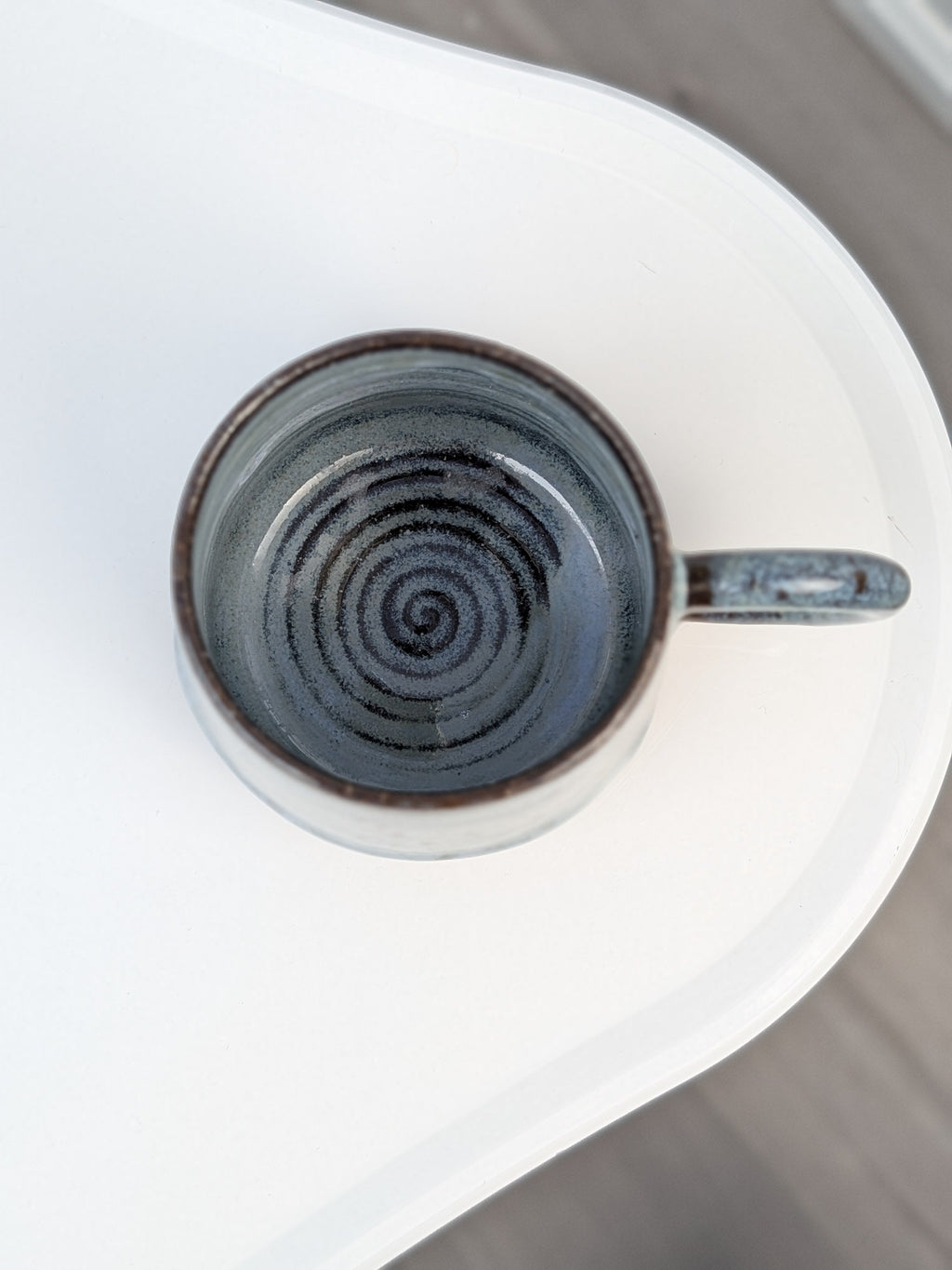 Handmade blue and black glazed ceramic cup, top view