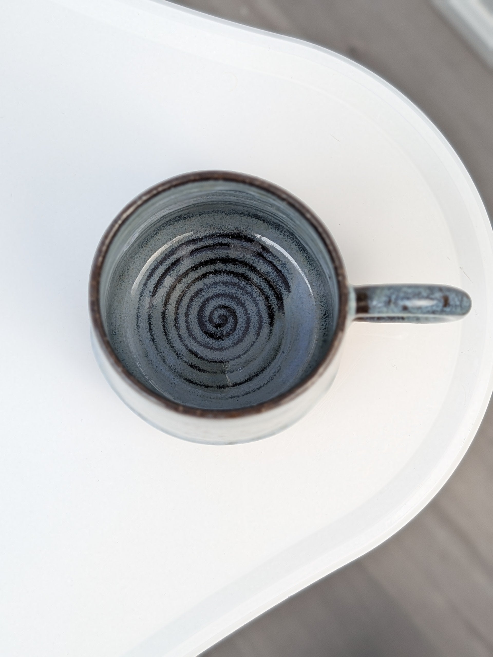Handmade blue and black glazed ceramic cup, top view