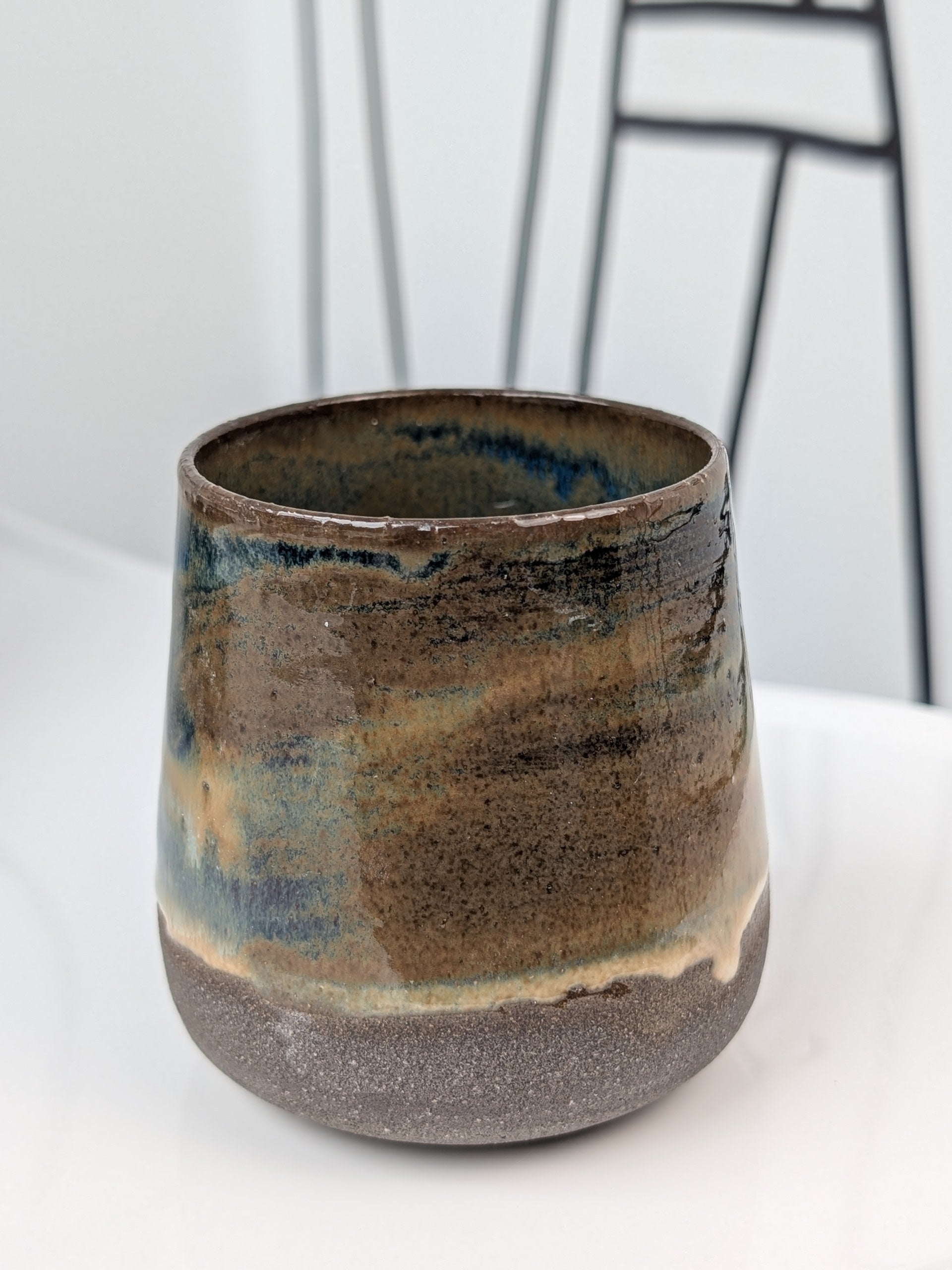 Handmade blue and brown glazed ceramic cup, front view